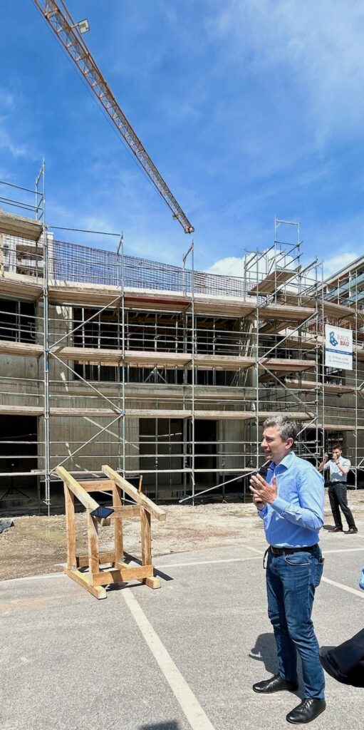 Mann in Jeans und blauem Hemd vor der Baustelle des Stadtteilhause