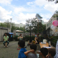 Kinder lauschen drei Musikanten beim Wohnhoffest Hopfgartenstraße 2024