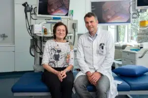 Ein Bild, das zeigt zwei Menschen, eine Frau und einen Mann, in einem Raum mit medizinischen Geräten.