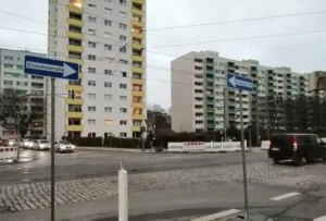 Kreuzung mit Hochhäusern im Hintergrund und Einbahnstraßenschildern auf beiden Seiten