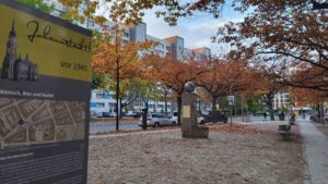 Herbstszene am Bönischplatz in der Johannstadt mit Denkmalschild im Vordergrund.