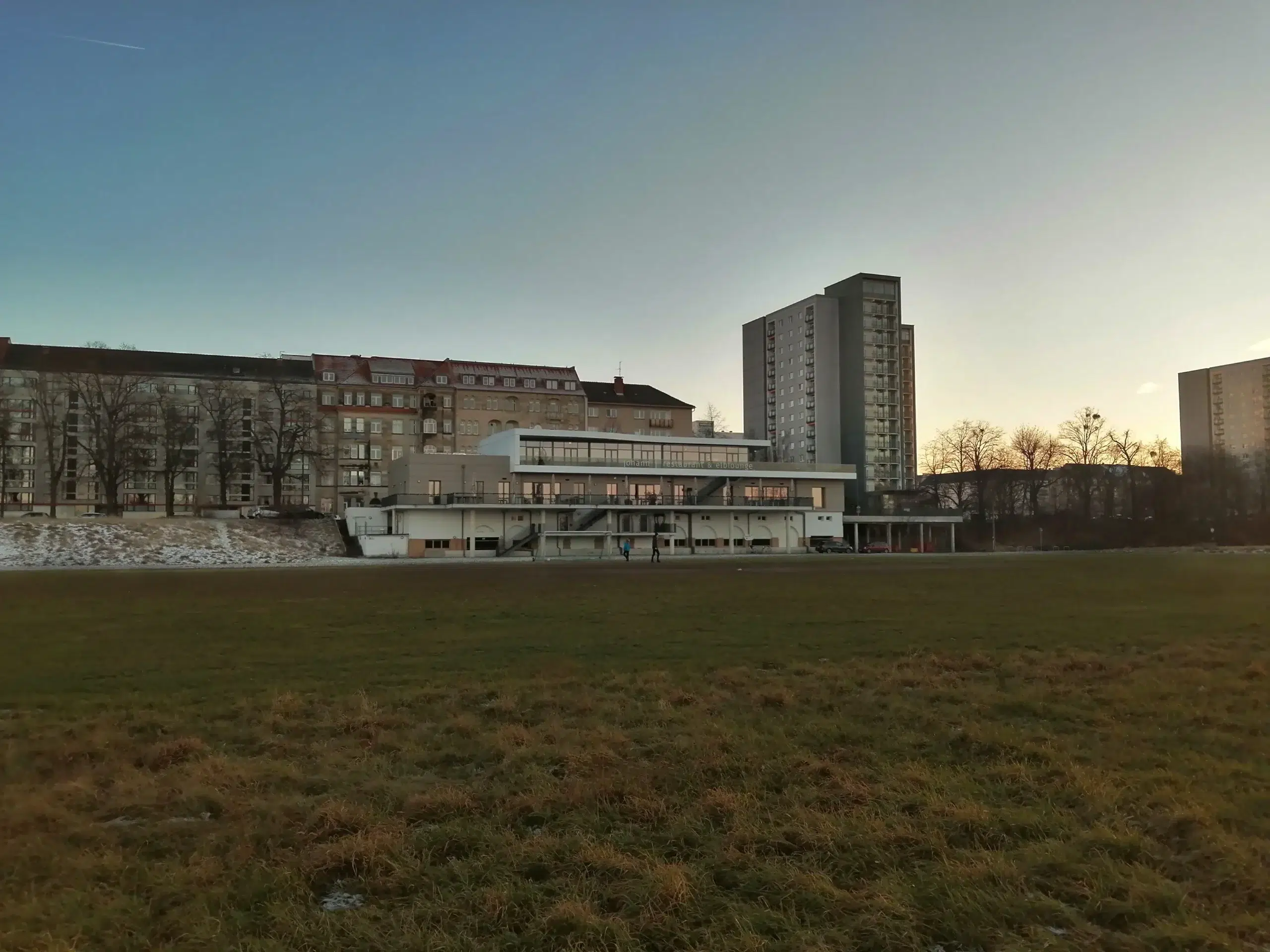 Grüne Wiese, Gebäude, blauer Himmel, Sonnenuntergang.