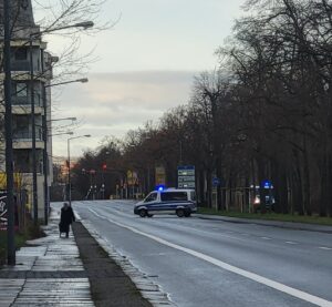 Ein Polizeiauto sperrt die Straße ab.