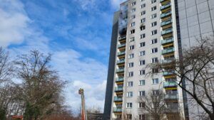 Brennendes Hochhaus mit Feuerwehrdrehleiter